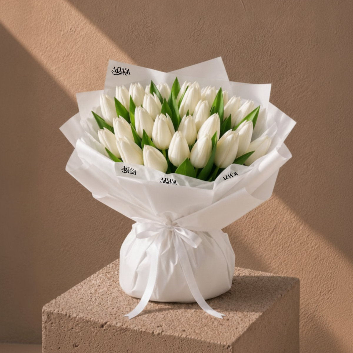 Radiant Tulips white tulip bouquet in white wrapping on a plinth by AIWA Flowers