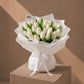 Radiant Tulips white tulip bouquet in white wrapping on a plinth by AIWA Flowers