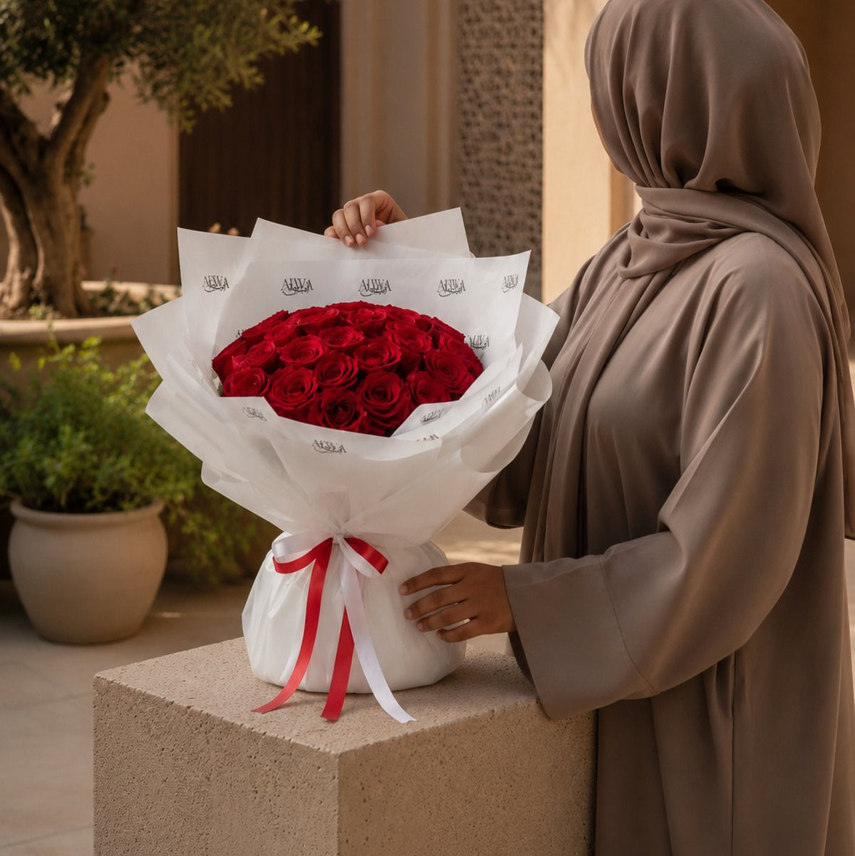 Woman holding a red rose bouquet in white wrap with a red ribbon - Red Love by AIWA Flowers
