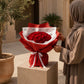 Woman with a red rose bouquet in red wrap and a red ribbon - Romance by AIWA Flowers