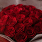 Close-up of deep red roses in red wrapping by AIWA Flowers