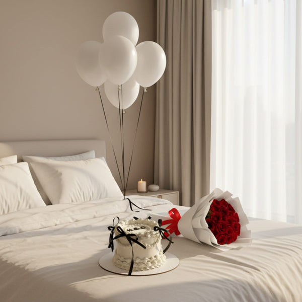 romantic bedroom setup with red rose bouquet vanilla cake and white helium balloons on bed in soft natural light
