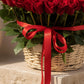 Close-up of red roses in a wicker basket tied with a red ribbon by AIWA Flowers