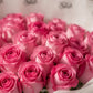 Close-up of vibrant pink roses in white wrapping by AIWA Flowers