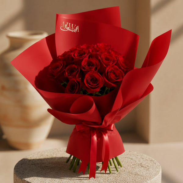 Close-up of deep red roses in red wrapping by AIWA Flowers