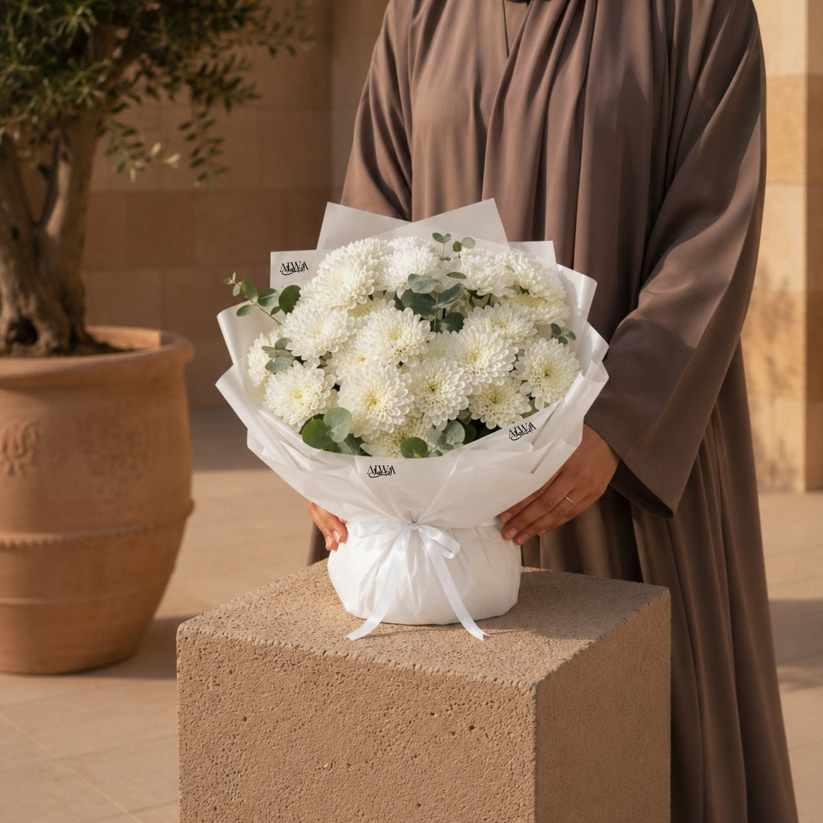Woman holding a white chrysanthemum bouquet by AIWA Flowers Dubai