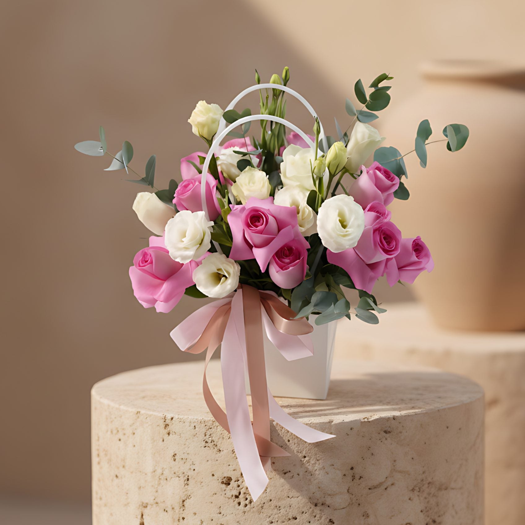 Soft Smiles white bag arrangement with pink and white roses, lisianthus and eucalyptus