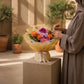 Woman holding Splendor bouquet of pink and orange roses, hydrangea and orchid in soft yellow wrap - AIWA Flowers