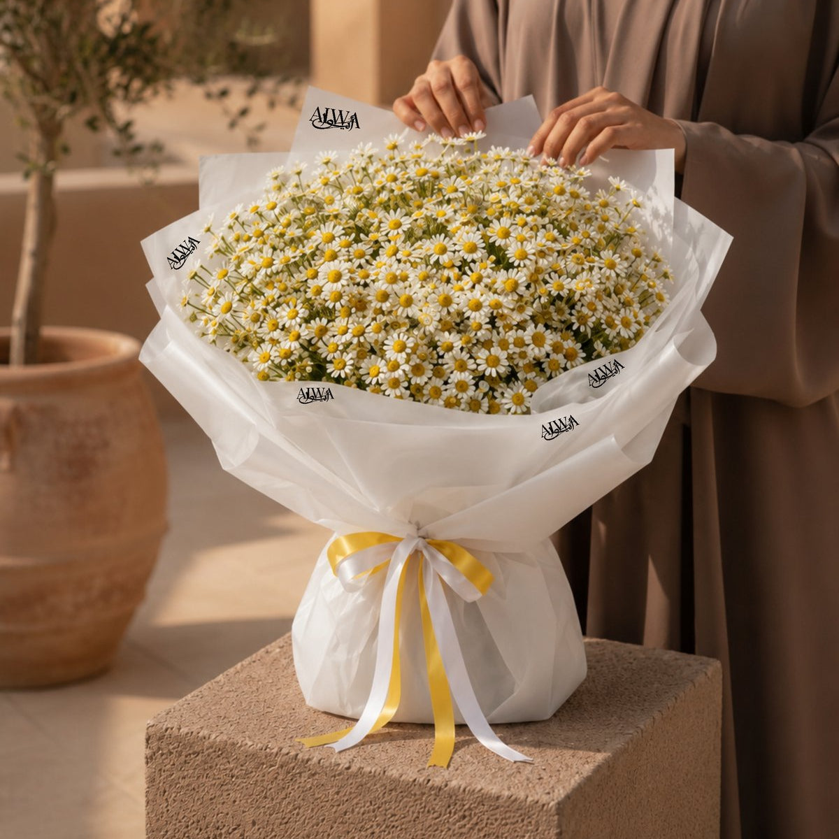 Woman holding a white daisy bouquet by AIWA Flowers Dubai