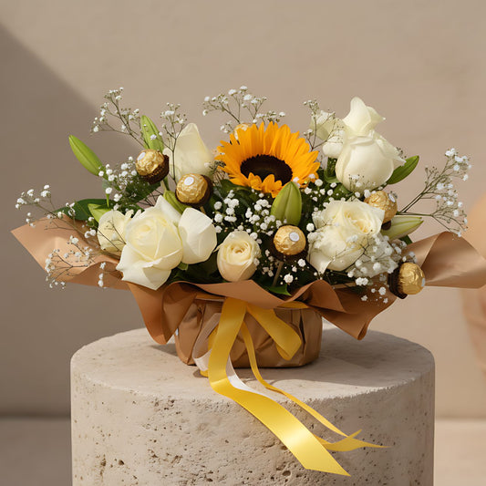 Sunny Day hand-crafted bouquet with white roses, sunflower, lilies, gypsophila and Ferrero Rocher chocolates in gold wrapping