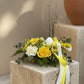Easter centerpiece with yellow roses, white carnations, and ceramic bunny egg holder on moss base, Aiwa Flowers Dubai