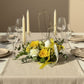Easter table styled with yellow floral centerpiece featuring bunny detail and soft ribbon accents