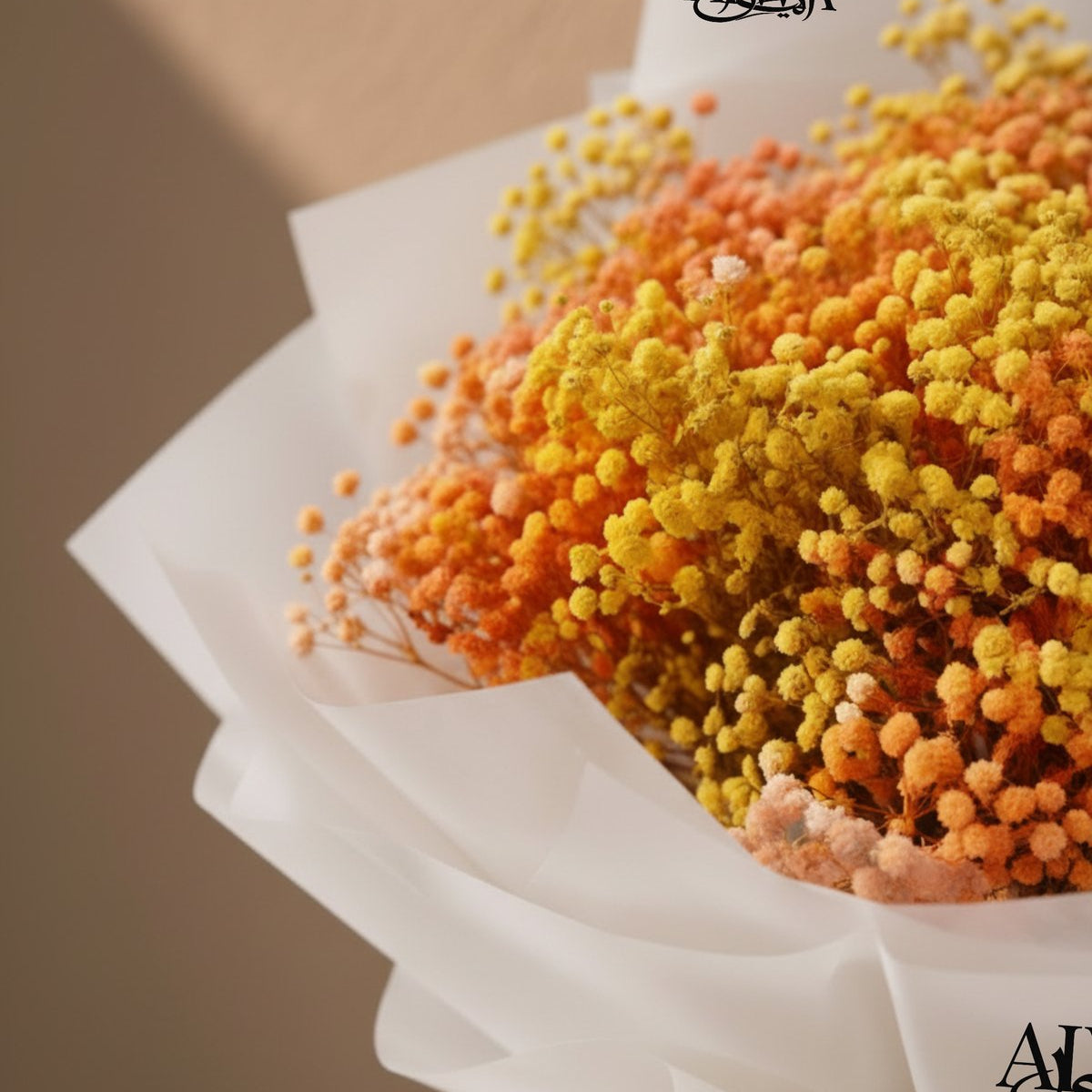 Close-up of orange and yellow gypsophila in crisp white wrapping - Sunny by AIWA Flowers