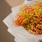 Close-up of orange and yellow gypsophila in crisp white wrapping - Sunny by AIWA Flowers