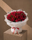 Full studio shot of a red tulip bouquet in white wrap with red and white ribbon - Tulip Wonderland by AIWA Flowers