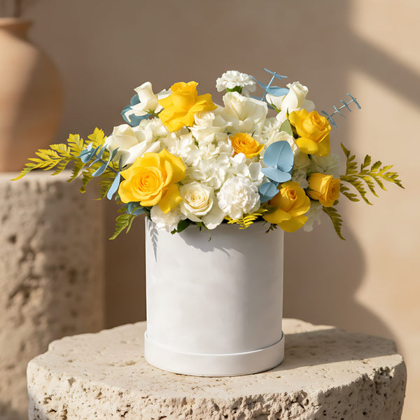 Unco white velvet flower box with yellow and white roses, white hydrangeas and blue eucalyptus