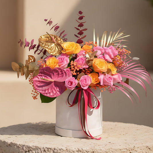 Vibrant white velvet flower box with orange and pink roses, anthuriums and gypsophila