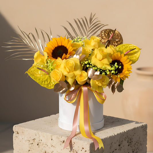 Vitamin white velvet flower box with yellow roses, sunflowers, anthuriums and gypsophila