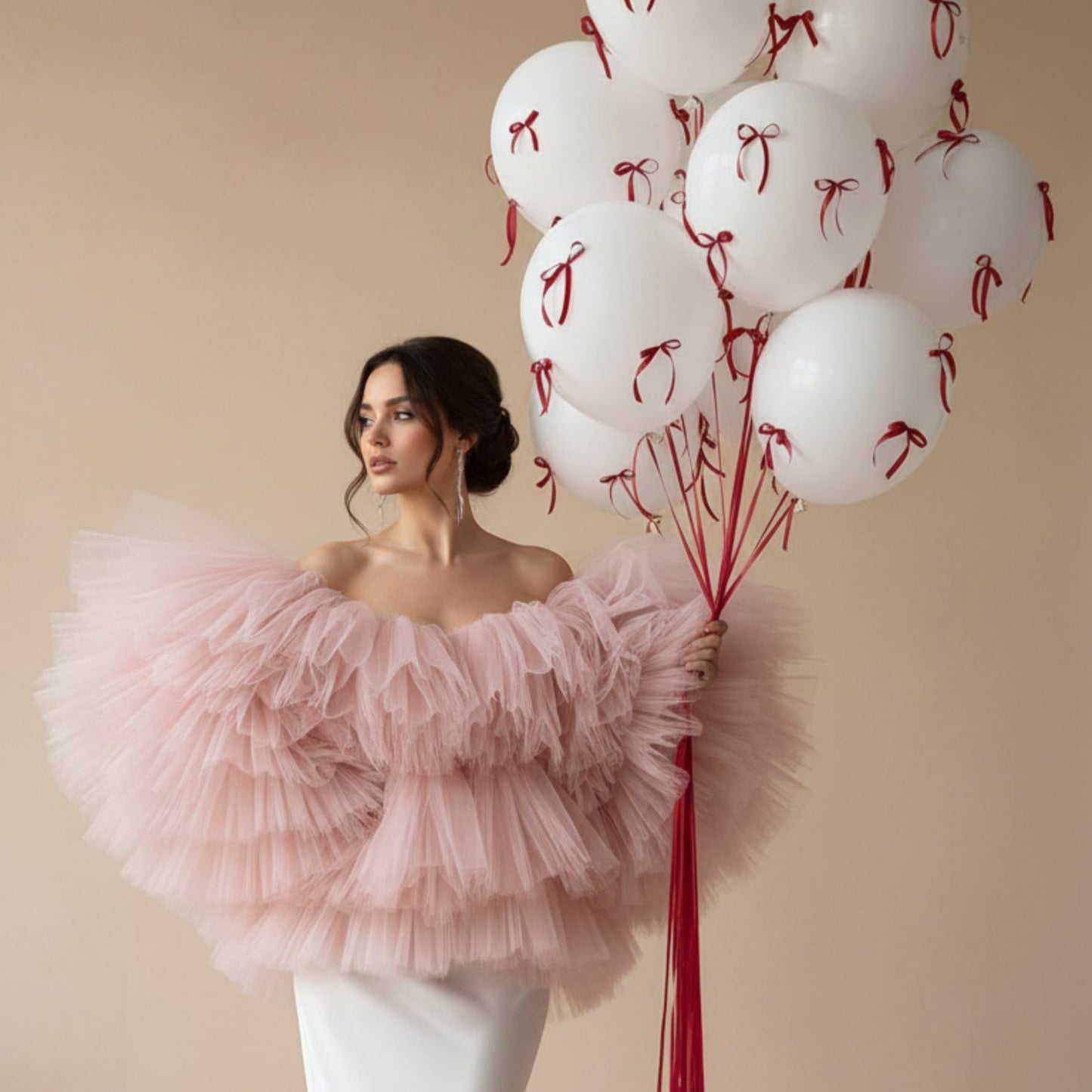 Elegant white helium balloon bouquet with red ribbon bows held by a woman in a luxury editorial setting