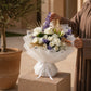 Woman holding a white rose bouquet with purple accents and gold leaves — White Velvet by AIWA Flowers