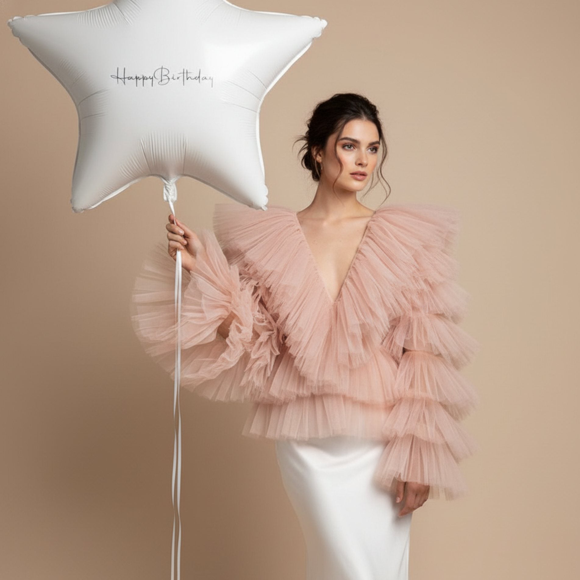 model holding white star birthday balloon